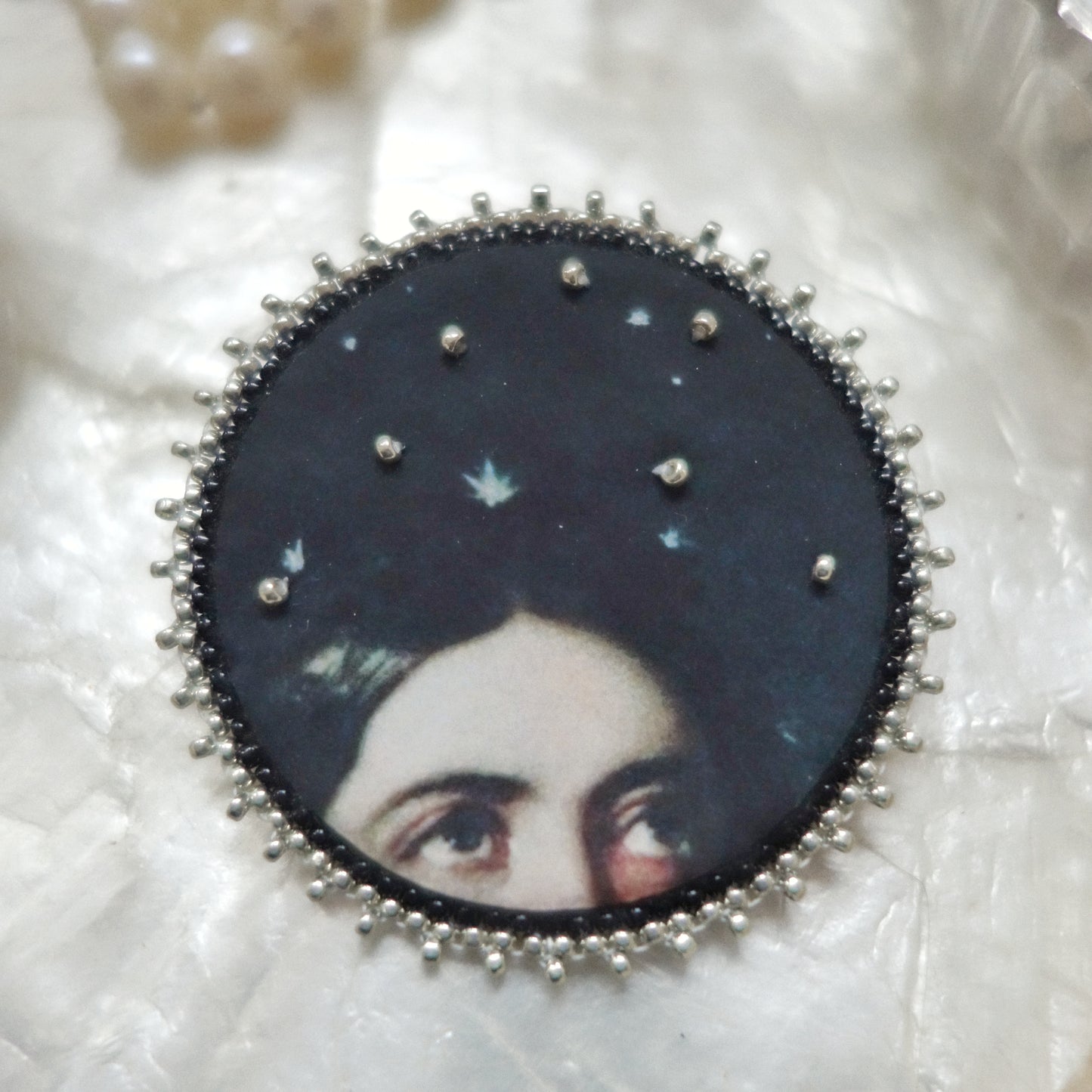 Broche yeux et ciel étoilé