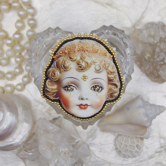 Broche tête de poupée