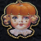 Broche tête de poupée citrouille
