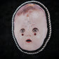 Broche tête de poupée