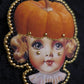 Broche tête de poupée citrouille