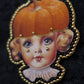 Broche tête de poupée citrouille