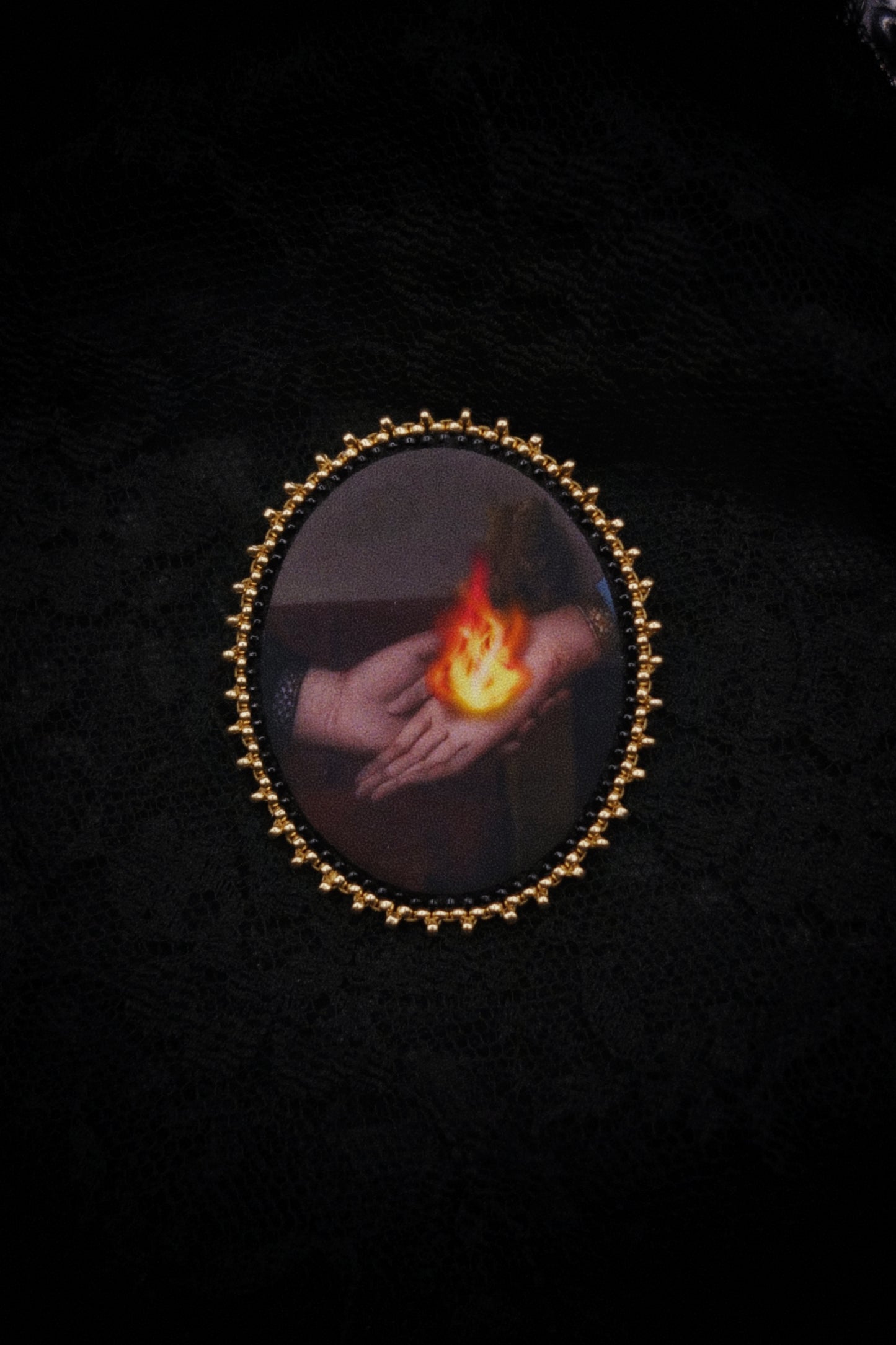 Broche mains et flamme