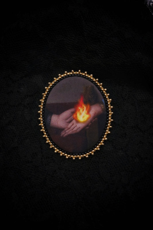 Broche mains et flamme