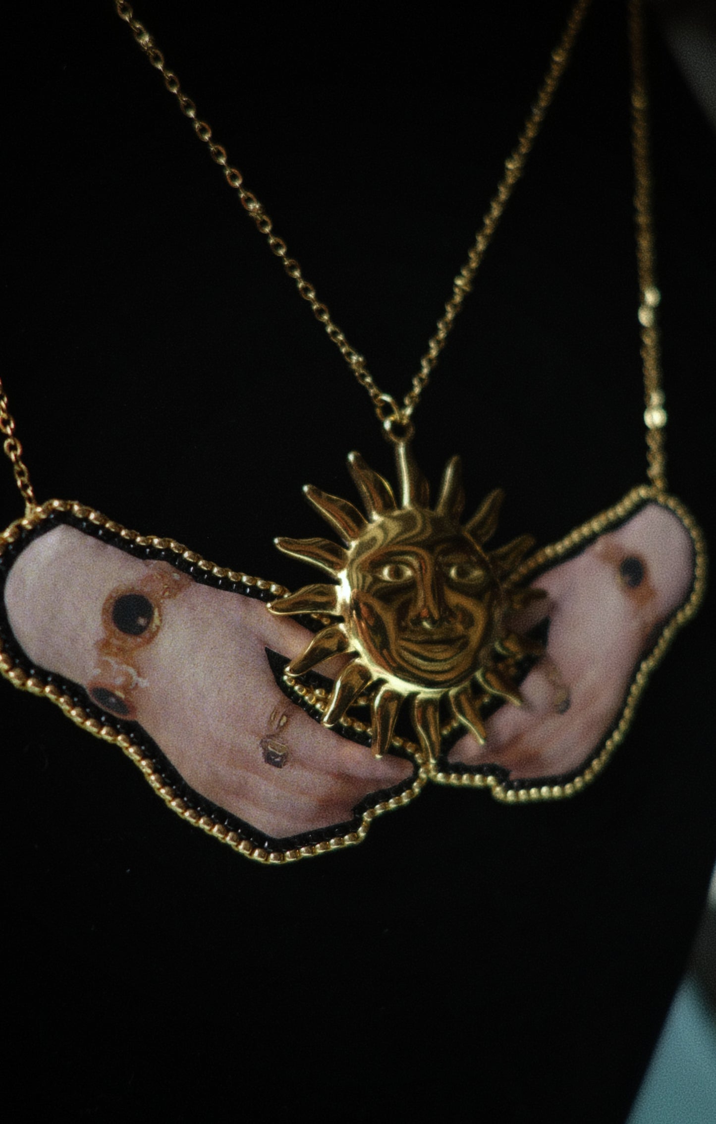 Collier soleil et mains