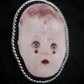 Broche tête de poupée
