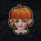 Broche tête de poupée citrouille